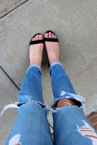 Black heeled sandals with light wash distressed jeans