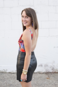 red floral bodysuit with leather mini skirt and blue tassel earrings