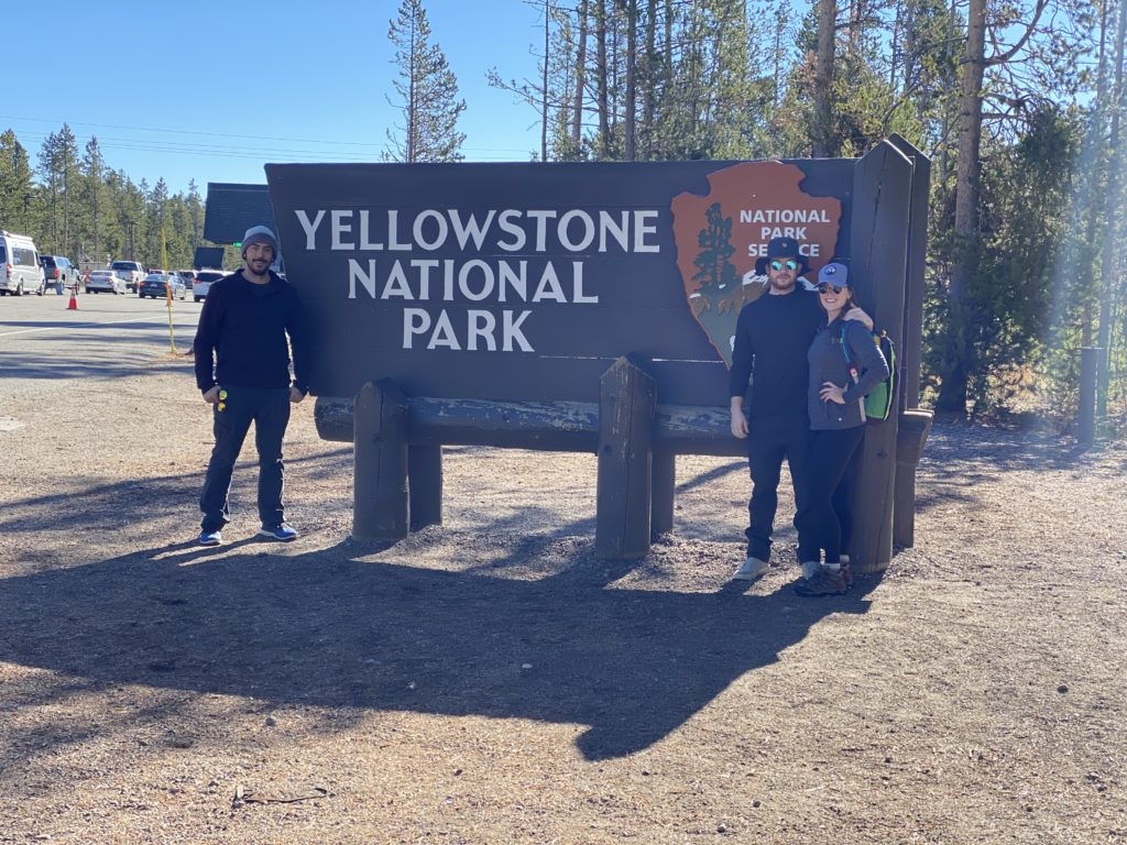 Photo with the Yellowstone National Park Sign by Madeline Mihaly